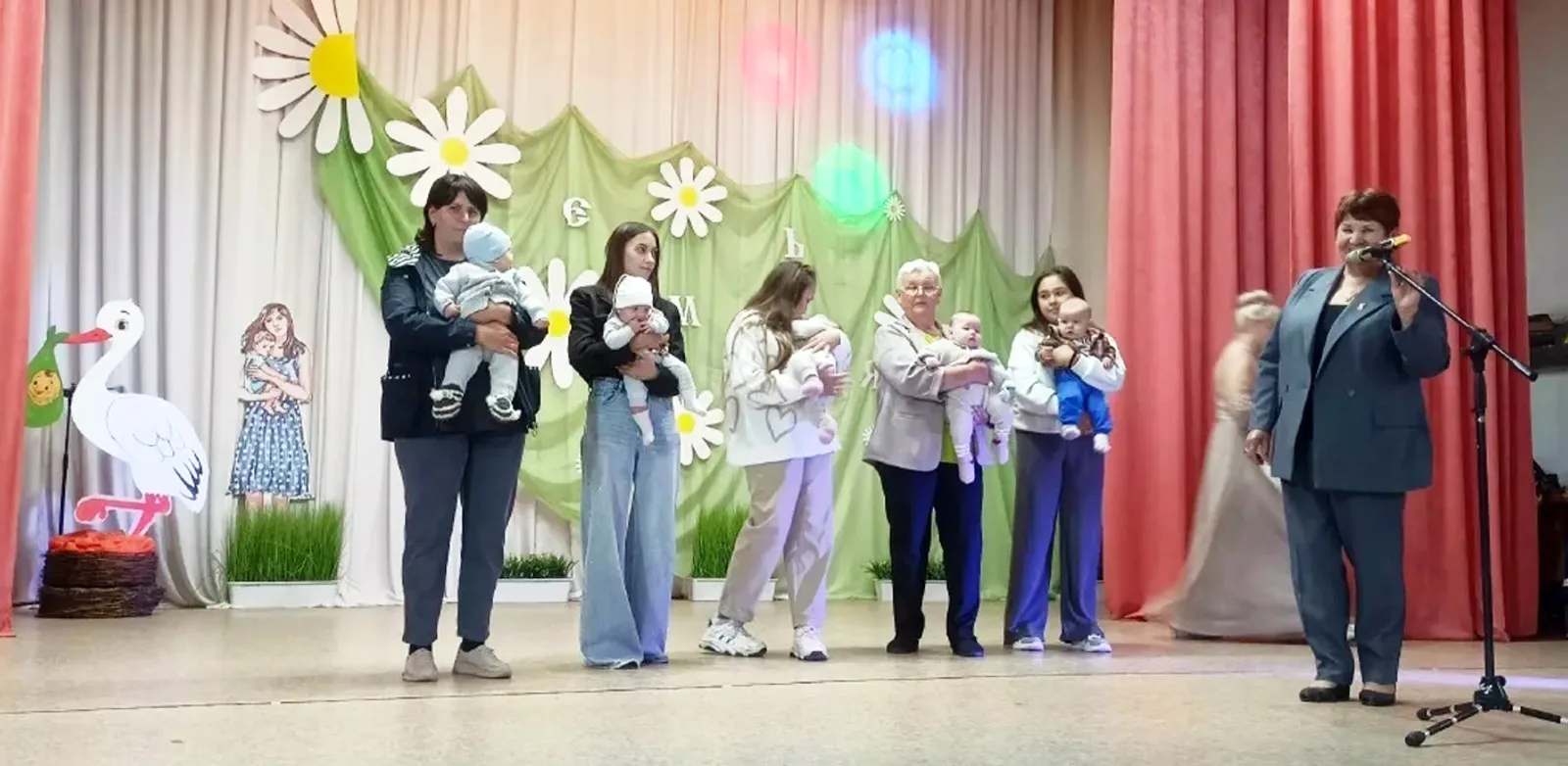Односельчане с улыбкой чествовали карапузов на руках у мам.
